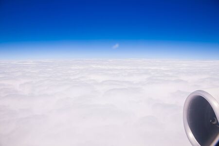 Bird eye view white cloudy and clear blue sky beside airplane engineの写真素材