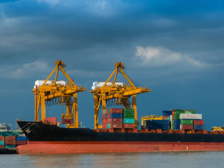 Photo of shipping of maritime transportation are under arrange big container loading in the big boat under big yellow crane at port authority of Thailandのeditorial素材