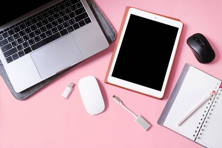 Top view working equipment with Laptop computers, tablet and wireless mouse on pink background.の写真素材