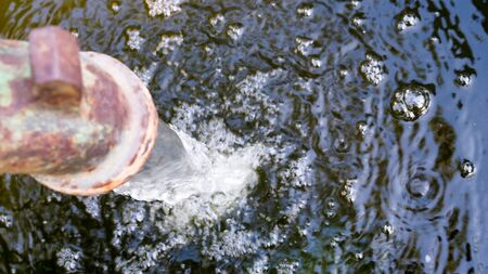 Water from pipes flows into well, Drought and water irrigation system.の写真素材