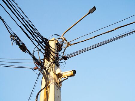 Electric wires on electricity poles in Asia with CCTV and led light lamp