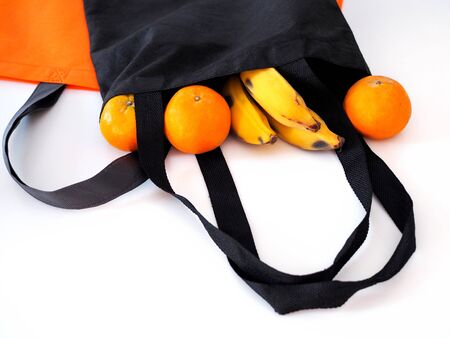 Fruit in a cloth bag with oranges and bananas isolated on white backgroundの写真素材