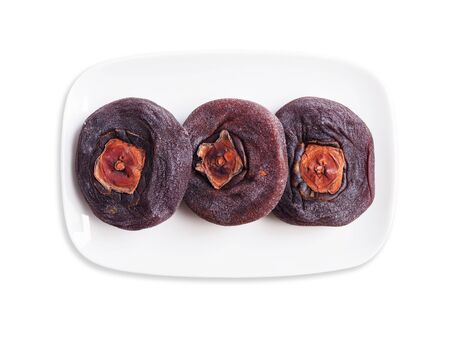 Top view of dried persimmons on white ceramic plate isolated on white background.の写真素材
