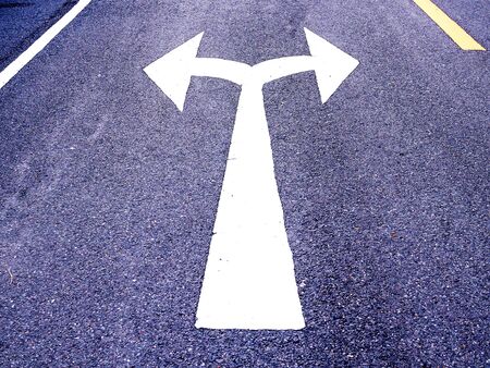 White arrow sign on asphalt road, Turn left and right signs on the road junction.