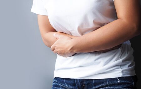Asian women suffering with severe stomach pain, Stomach ache or menstrual pain.の写真素材