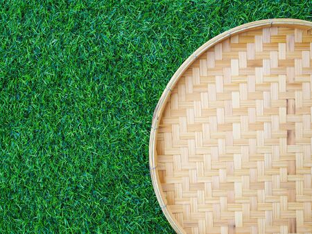 Bamboo weave trays container for Thai food on green grass with copy space for design.の写真素材