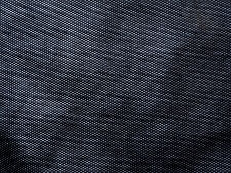 Abstract background texture of black mesh fabric.