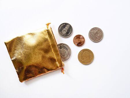 Top view of Thai money coins in golden bag on white background, Collecting money for investment conceptの写真素材
