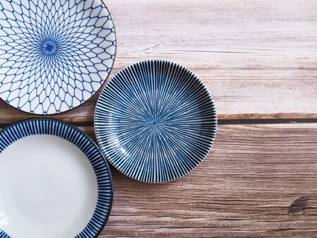 Top view of empty ceramic round plate isolated on wooden table.