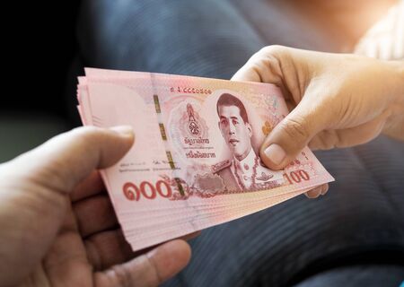 submitting Thai baht banknote money of thailand to hand that is waiting receive, Payment, bribery or...