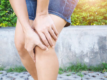 Young Asian Thai women with body aches suffering muscle injury with knee pain and leg pain