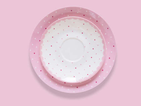 Top view of round ceramic stacked plate set, tableware pink dish isolated on pink backgroundの写真素材