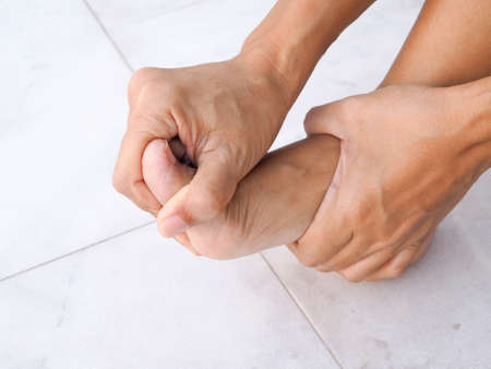 foot injury use hand massage on feet to relax muscle from heel pain, ankles and bones from...