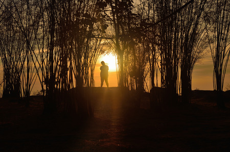 Silhouette of young man in a beautiful sunset sky.の写真素材