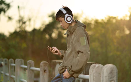 Young boy using a smart phone outdoorsの写真素材
