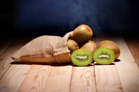 Kiwi friut in sack on floor wood and black backgroundの写真素材