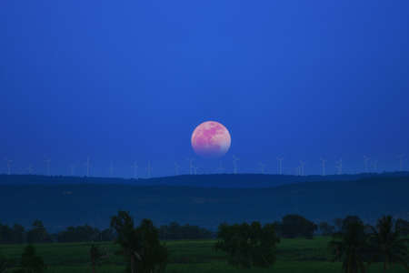 Full moon and turbine on mountainの写真素材