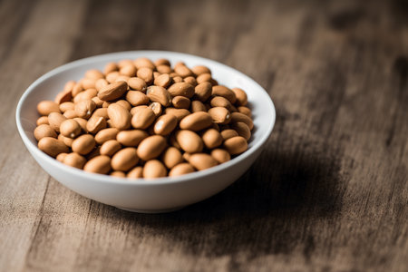 Peanuts in a white bowl on a wooden background. Selective focus.の素材
