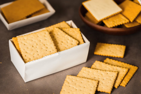 Salty crackers in a bowl on a dark background. Selective focus.の素材
