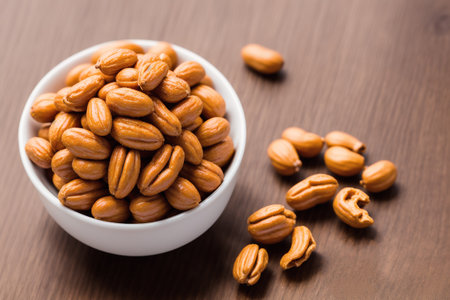 Almond nuts in white bowl on wooden background. Selective focus.の素材