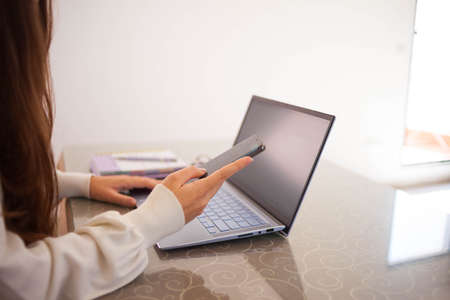 Head shot pleasant happy young woman freelancer working on computer at home. Attractive businesswoman studying online, using laptop software, web surfing information or shopping in internet store. Young brown haired woman doing online shopping.の写真素材