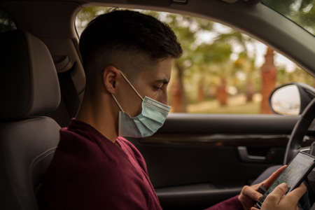 portrait of a man wearing surgical mask inside a car. Portrait of a man wearing surgical mask inside...