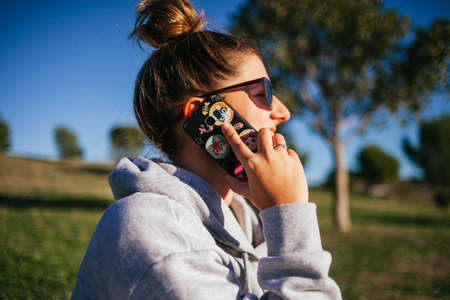 woman using mobile phone in the field. Young woman smiling. Young woman taking a selfieの写真素材