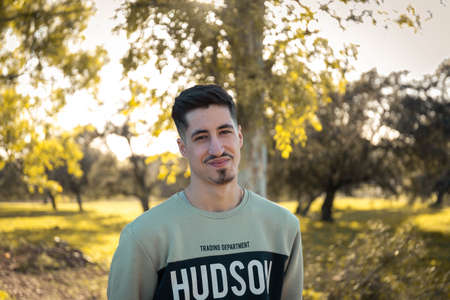 Portrait of a young man in nature. Attractive and happy man. Smiling