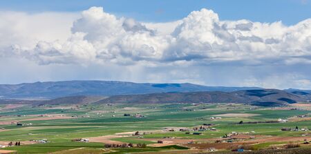 A panoramic view of Ellensburg, WA with a thunderstorm in the distance on a sunny dayの写真素材
