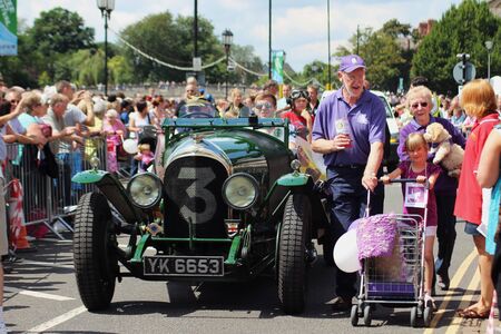 Bedford, England - July 21 - An old car accompanies the Canine Partners charity in the carnival at the bi-annual Bedford River Festival in England on 21 July 2012のeditorial素材