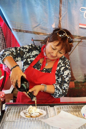 Bedford, England - July 21 - Lady prepares traditional Dutch pancakes in the European market at the bi-annual Bedford River Festival on 21 July 2012 in Englandのeditorial素材