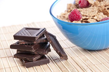 Bowl of cornflakes with raspberries and chocolate bars の写真素材