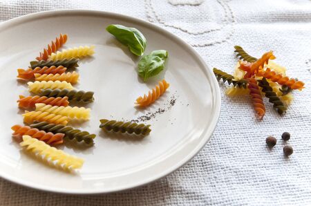 Colorful fusilli with basil and spicesの写真素材