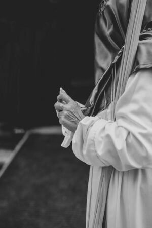 Woman putting on gloves during a procession in Holy Weekの写真素材