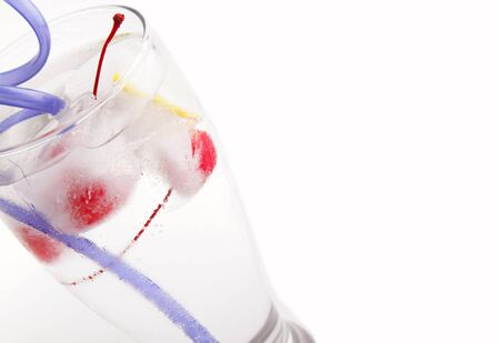 glass of water with frozen fruit inside the ice cubeの写真素材