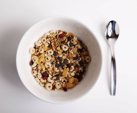 white bowl of cereal and spoon for the brealfastの写真素材