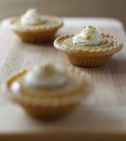 mini maple syrup tart on a wooden board with a fork. Focus on the middle portion.Shallow depth of field.の写真素材