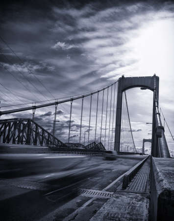 Bridge from canada with fast moving car on the road. Black and white with blue tint and vignetting...