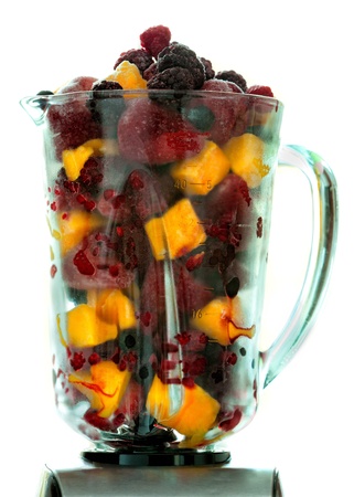 Frozen fruit in a glass pitcher blender  for a healthy smoothie. Backlit with white background.の写真素材