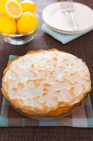 Whole homemade citrus pie with fruit and plate in the background  Focus on the meringue with shallow depth of field の写真素材