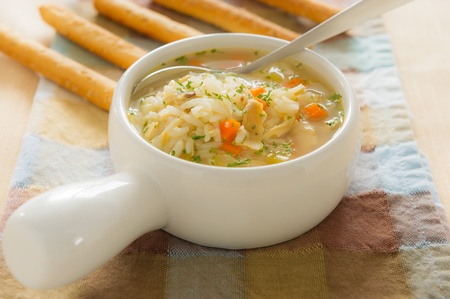Healthy chicken rice soup with spoon. Shallow depth of field.の写真素材
