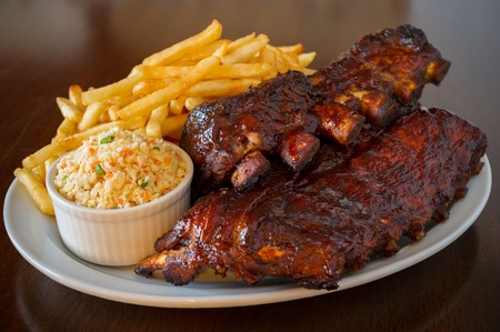 Pork ribs back with french fries and coleslaw salad on the side. Shallow depth of field.の写真素材
