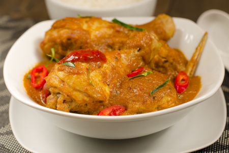 Kari Kapitan - Malaysian spicy chicken curry with coconut milk garnished with kaffir lime leaves, red chilies and sambal oelek  Served with rice  Close up  Traditional Nyonya Cuisine の写真素材