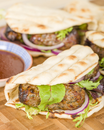 Lamb Kebabs in Flatbread - Minted minced lamb kebabs in flatbreads with salad and sauces.の写真素材