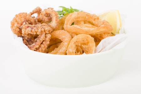 Calamari - Deep-fried squid rings served with lemon on a white background.の写真素材