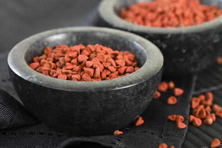 Annatto Seeds - Annatto achiote seeds in a black bowl.の写真素材