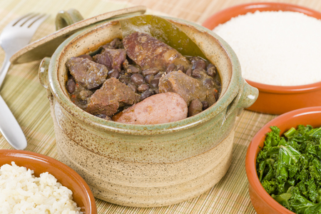 Feijoada - Brazilian beef, sausage, pork and black bean stew served with manioc flour, kale and white rice.の写真素材
