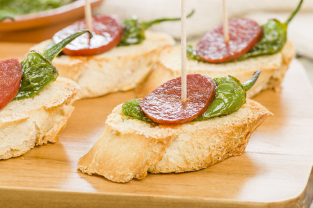 Chorizo  Padron Peppers Pinchos - Spanish tapas with sliced crusty bread, spicy sausage and fried green peppers.の写真素材