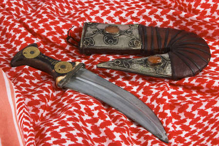 Arab dagger with Maria Theresia taler coins on a keffiyah headscarf.