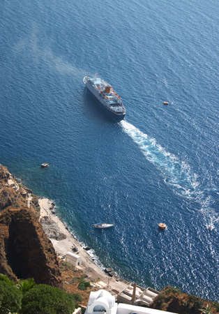 A cruise ship leaving Fira harbour, Santorini, viewed from Fira Town on the clifftop high above.の写真素材